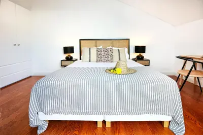 a bedroom with a large bed with a wooden floor at Young Spirit Apartment in Faro