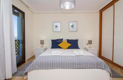 a bedroom with a large bed with blue and yellow pillows at Apartment Pine View- Falesia Beach By Dalma Portuguesa in Albufeira