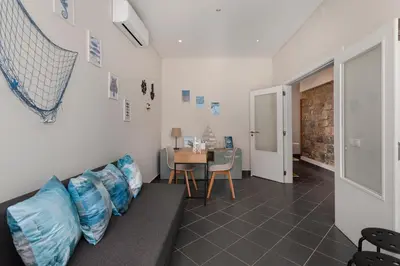 a room with a couch with blue pillows and a table at Lemon Hostel Faro in Faro