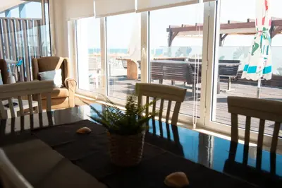 a living room with a table and chairs and a balcony at Wax Suite By the sea in Faro