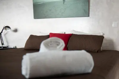 a bedroom with a bed with brown and white pillows at Wax Suite By the sea in Faro