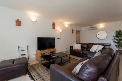 a living room with a leather couch and a flat screen tv at The Albufeira Concierge - Moinho Sea Views & Pool in Albufeira
