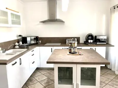 a kitchen with white cabinets and a counter top at The Albufeira Concierge - Moinho Pool & Gardens in Albufeira