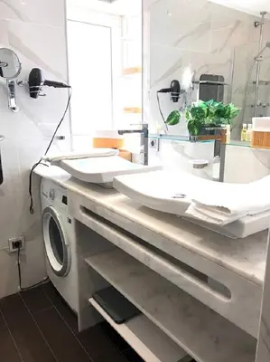 a bathroom with two sinks and a washing machine at The Albufeira Concierge - Moinho Pool & Gardens in Albufeira