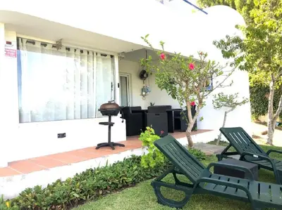 two green chairs in front of a house at The Albufeira Concierge - Moinho Pool & Gardens in Albufeira
