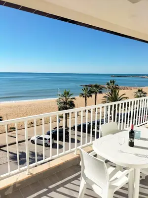 a balcony with a table and chairs and the beach at T2-MAMAMIA II Frente Mar in Quarteira