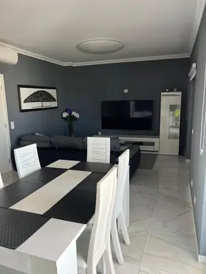 a dining room with a table and a couch at Casa das Oliveiras o seu refugio no Algarve in Quarteira