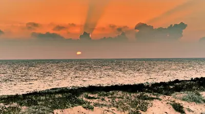 a sunset over the ocean with the sun in the sky at Apartamentos Barracuda in Faro