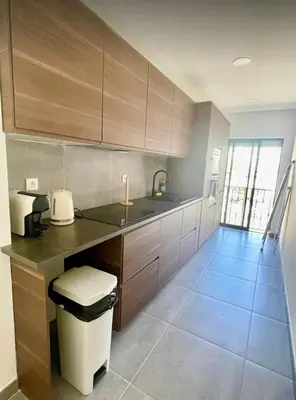 a kitchen with wooden cabinets and a counter top at Pontinha Exclusive Apartment in Faro