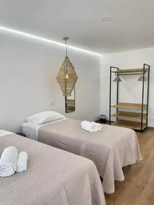 a bedroom with two beds with white sheets and a chandelier at Pontinha Exclusive House in Faro
