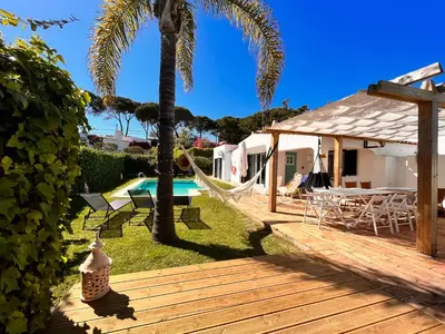 a backyard with a hammock and a swimming pool at Amazing - VillaAnas Balaia in Albufeira