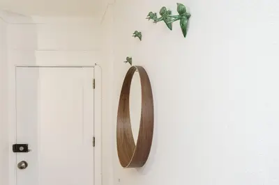 a wooden mirror hanging on a wall next to a door at TENNIS GOLF MAR - Apartamento renovado para 4 com AC e piscina in Vilamoura