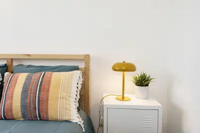 a bedroom with a bed and a lamp on a night stand at TENNIS GOLF MAR - Apartamento renovado para 4 com AC e piscina in Vilamoura