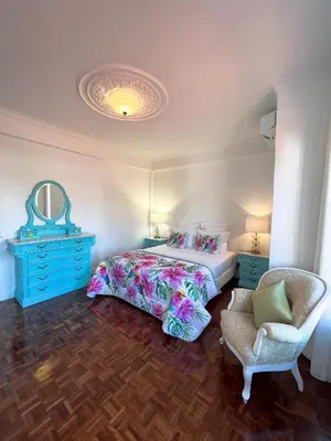 a bedroom with a bed and a chair and a mirror at Sunshine Villa with Heated Pool in Faro