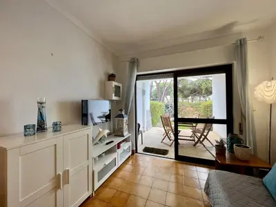 a living room with a television and a door to a patio at Albufeira Cosy by Homing in Albufeira