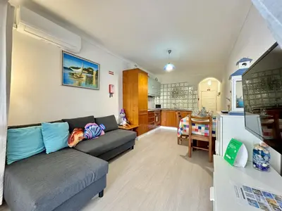 a living room with a couch and a kitchen at Albufeira Cosy by Homing in Albufeira
