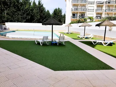 a resort with a pool and chairs and umbrellas at 1 Bedroom Apartment Chaves, Praceta Vitorino Nemesio, Albufeira in Albufeira