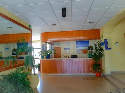an office lobby with a reception desk and potted plants at 1 Bedroom Apartment Chaves, Praceta Vitorino Nemesio, Albufeira in Albufeira