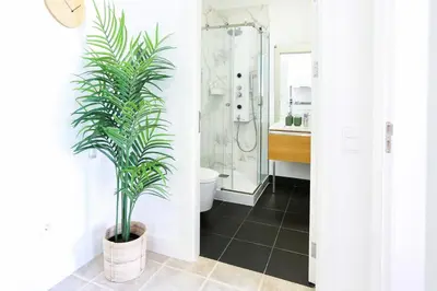 a bathroom with a toilet and a plant at Ice Cream Call Apartments in Faro