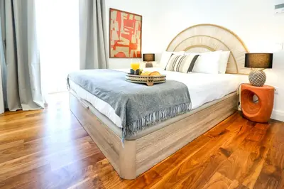 a bedroom with a large bed and a wooden floor at Vacation Time Apartment in Faro