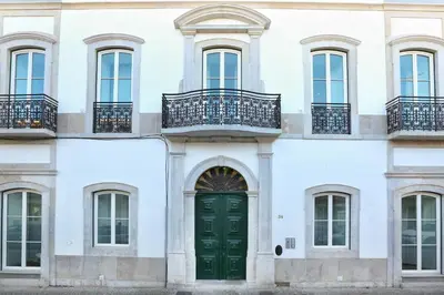 a facade of a white building with a green door at Vacation Time Apartment in Faro