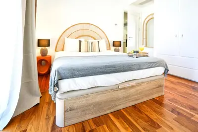 a bedroom with a large bed with a wooden floor at Vacation Time Apartment in Faro
