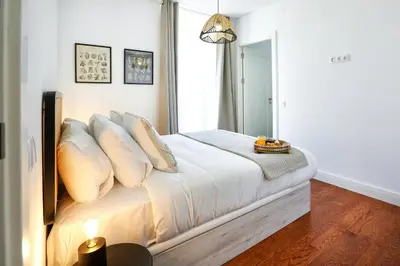 a bedroom with a bed with white sheets and pillows at Querido Algarve Apartment in Faro