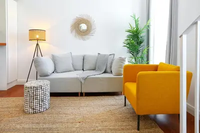 a living room with a couch and a chair at Querido Algarve Apartment in Faro