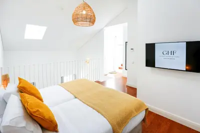 a bedroom with a bed and a tv on a wall at Querido Algarve Apartment in Faro