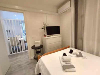 a bedroom with a bed and a tv and a window at Casa Docim, casa tipica algarvia no centro da cidade velha in Albufeira