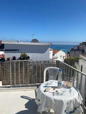 a table on a balcony with a view of the ocean at Casa Docim, casa tipica algarvia no centro da cidade velha in Albufeira