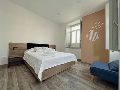 a bedroom with a large bed with a tree mural on the wall at Leevin Guesthouse in Faro