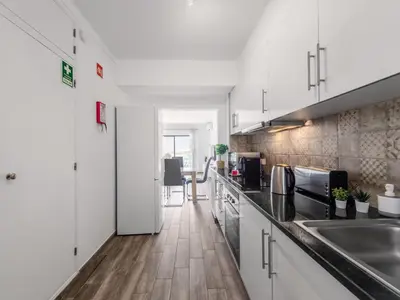 a kitchen with white cabinets and a wooden floor at Apartment Happy Moments by Interhome in Albufeira