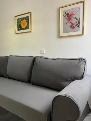a couch in a living room with two pictures on the wall at Apartamento Batalha - Quarteira, Algarve, Portugal in Quarteira