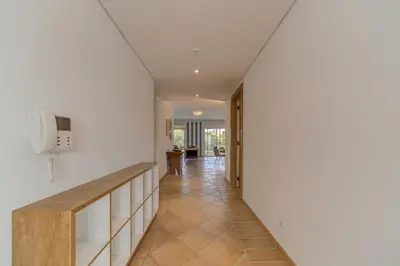 a hallway of a house with white walls and tile floors at Vila Sol Apartamento fantástico 3 quartos piscina in Quarteira