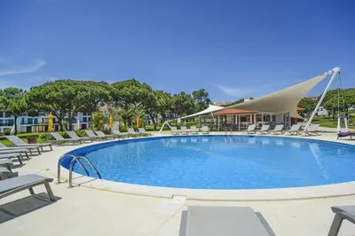 a large swimming pool with lounge chairs at Vila Sol Apartamento fantástico 3 quartos piscina in Quarteira