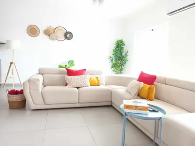 a white living room with a white couch and a table at V3 Olhos dÁgua com piscina AC wifi 800m praia in Olhos de Água