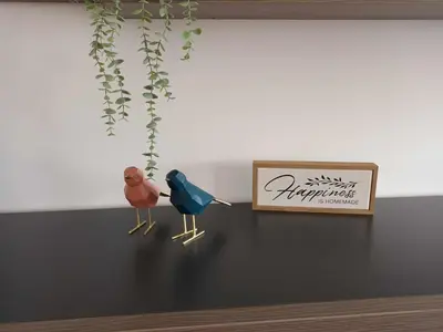 two birds sitting on a table next to a sign at V3 Olhos dÁgua com piscina AC wifi 800m praia in Olhos de Água
