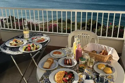 a table with plates of food on a balcony at Monicca Collection Suites and Residences in Albufeira
