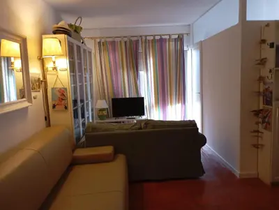 a living room with a couch and a desk with a computer at Albufeira Home in Albufeira