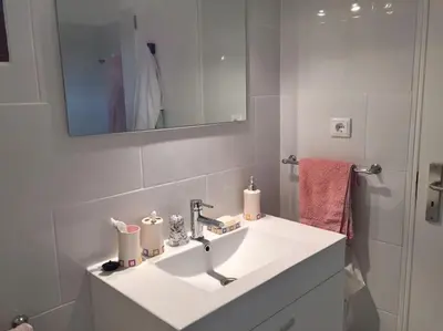 a white bathroom with a sink and a mirror at Albufeira Home in Albufeira