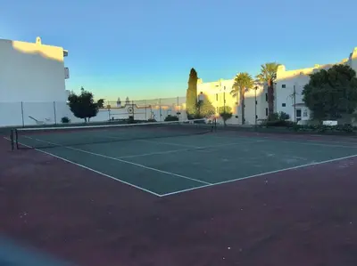a tennis court in front of a building at Albufeira Home in Albufeira