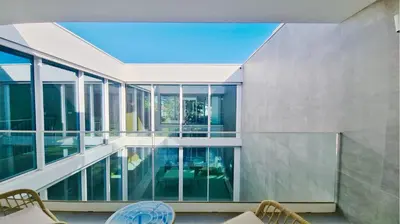 an indoor balcony of a house with glass windows at Villa Miya - Clever Details, walking distance from the Marina, restaurants, bakeries and supermarkets,, free wifi, pool in Vilamoura