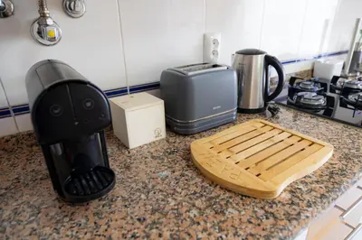 a kitchen counter with a cutting board and a toaster at JAZZ & SILVIA - Moderno & Central apenas a 5 min da praia dos Pescadores in Albufeira