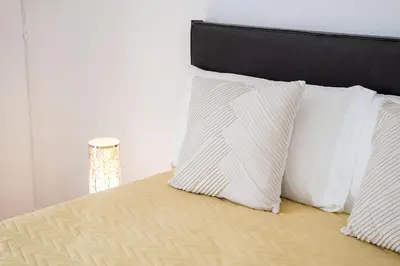 a bed with white pillows on top of it at My Place @ Faro Skyline in Faro