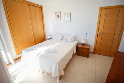 a bedroom with a large bed with white sheets at Excellent Sea view 1 Bedroom Apartment, Verandas do Mar, Olhos de Agua AT05 in Olhos de Água