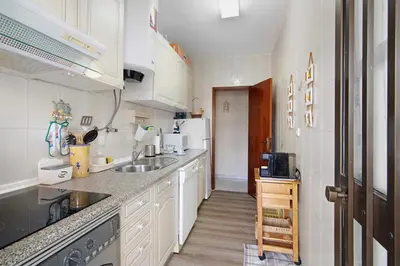 a kitchen with white cabinets and a sink at Mouramar Vilamoura in Vilamoura