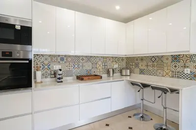 a kitchen with white cabinets and a stove top oven at Casa SP- Villa with heated pool near Vilamoura, Vale do Lobo in Quarteira