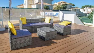 a set of chairs and tables on a deck at Casa SP- Villa with heated pool near Vilamoura, Vale do Lobo in Quarteira