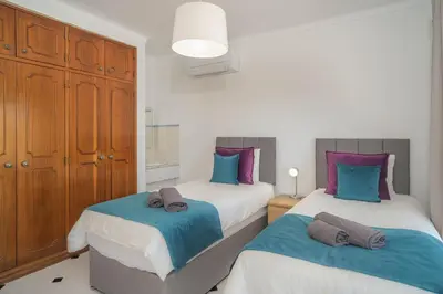 a bedroom with two beds with blue and purple pillows at Casa SP- Villa with heated pool near Vilamoura, Vale do Lobo in Quarteira